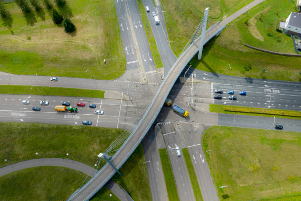 istock Traffic at a junction with a winding bicycle path bridge seen from above 2195238359