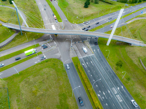 istock Traffic at a junction with a winding bicycle path bridge seen from above 2195238533