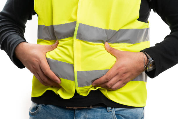 istock Close-up of builder touching bloated abdomen stomachache 2195240165