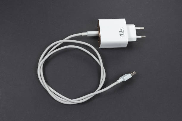 istock white smartphone charger on dark background. Charger and USB cable type C on dark background 2195240377