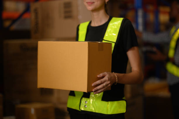 istock Close-up, workers carrying boxes in a large logistics warehouse. Concept of export-import logistics system. parcel box at warehouse, packaging, delivery, warehouse, banner image 2195241242