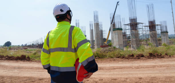 istock Asian architect engineer wearing safety uniform surveying and working at building structure checking blueprints construction site road general job details business concept architecture street 2195241997