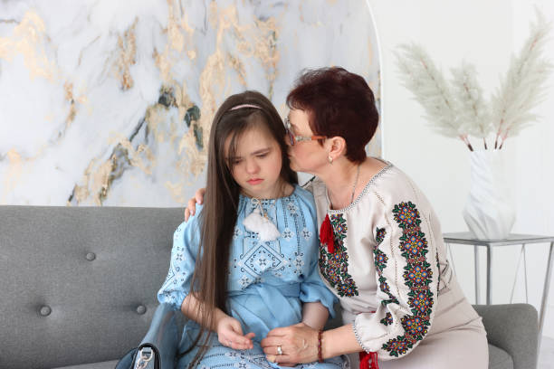 istock A mother is talking to her daughter with Down syndrome while sitting on the sofa. 2195242390