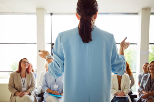 istock Back view female entrepreneur explaining strategy to colleagues during conference meeting at workplace 2195244207