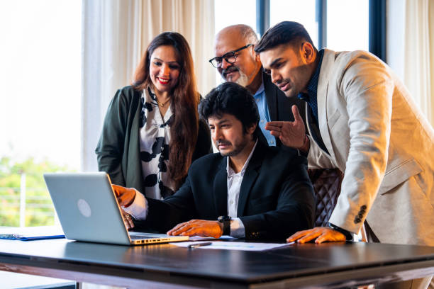istock Indian business team reviews reports and discusses serious matters in office workspace 2195246014