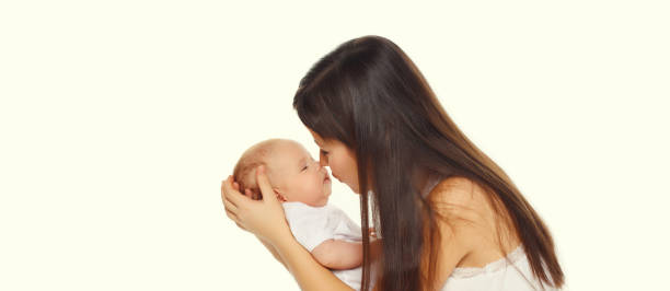 istock Happy young mother kissing baby on white studio background 2195246400