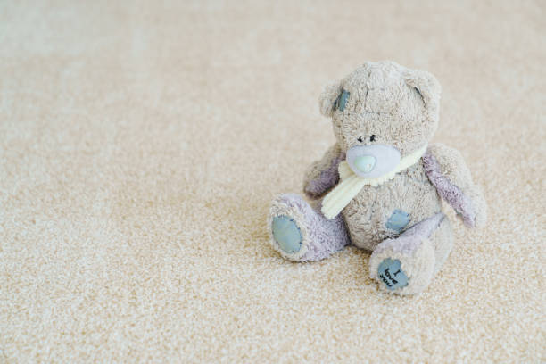 close-up. teddy bear on the beige Interior pile carpet made of polypropylene. Long fibers form a high pile. pleasant lint texture, softness and hypoallergenicity.