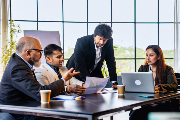 istock Indian business team reviews reports and discusses serious matters in office workspace 2195247750