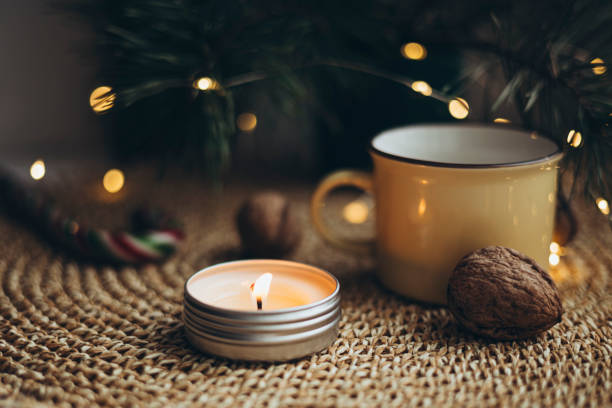Christmas cozy home background with candle and cup on windowsill, copy space.