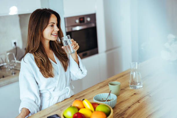 istock Woman Enjoying Morning Drink in Bright Modern Kitchen 2195248405