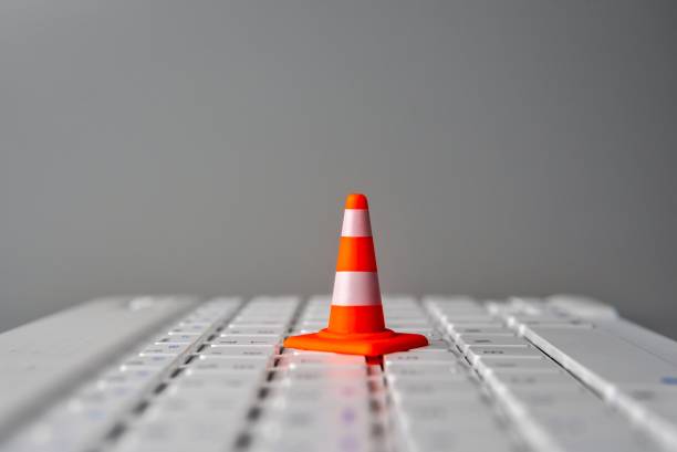 istock A miniature traffic cone on a laptop keyboard. 2195248563