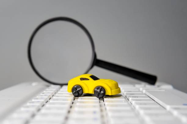 istock A magnifying glass and toy car on a laptop keyboard. 2195248568