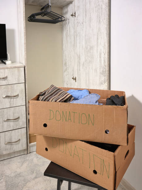 istock Vertical image a several a cardboard donation boxes with things, with an empty clothes closet in the background. 2195249394