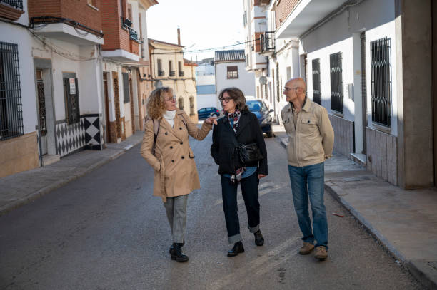 istock Three senior friends walking through a quiet town street 2195250390