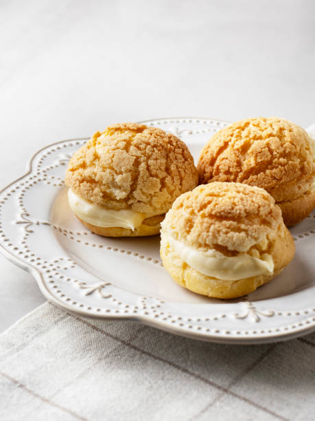 istock Chou pastry biscuits filled with whipped cream on grey background. Choux pastry. Homemade profiteroles with cream. Profiterole. Eclair. 2195253156