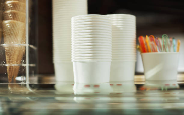 The stack of white paper cups on the coffee machine