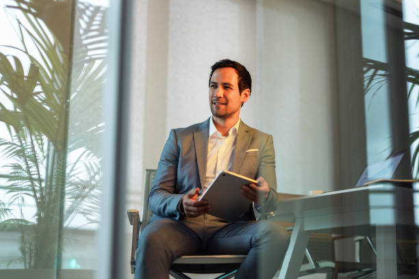 istock Confident Businessman in Moody Lighting with Tablet 2195255285