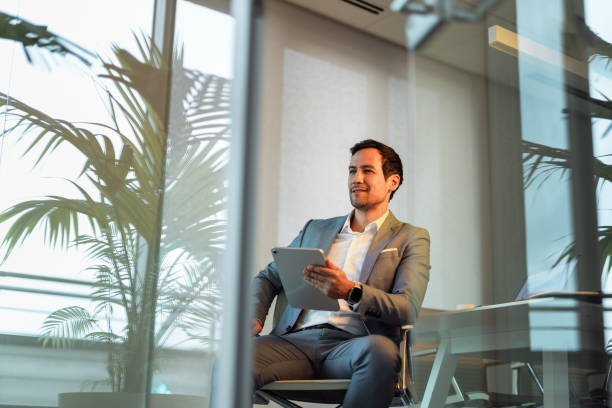 istock Confident Businessman in Modern Office Setting with Tablet 2195255299