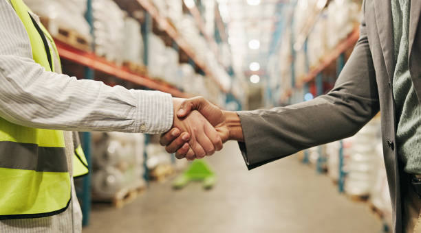 istock Shaking hands, people and deal at warehouse for logistics, distribution or b2b collaboration. Partnership, freight and agreement for stock, inventory or thanks for shipping, packaging or supply chain 2195258281