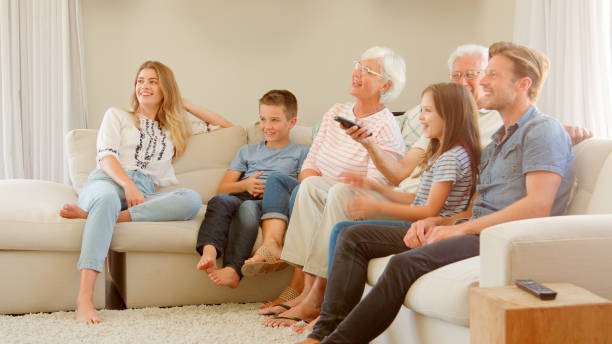 istock Multi Generation Family Sitting On Sofa At Home Watching TV 2195261683