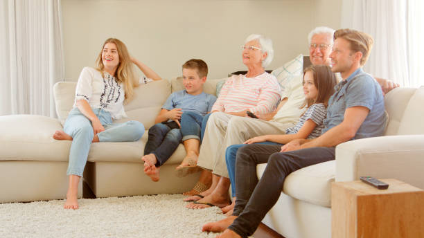 istock Multi Generation Family Sitting On Sofa At Home Watching TV 2195261751