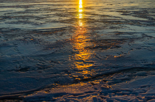 Reflection of the setting sun on the ice of a frozen lake