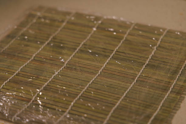 A visual guide illustrating the process of sushi preparation, including how to set up the bamboo mat and add delicious fillings