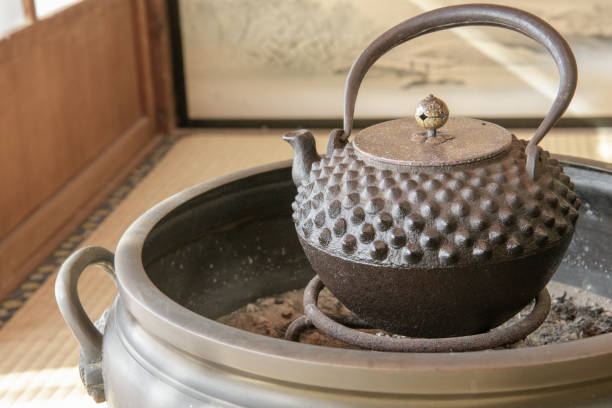 An iron kettle placed in a Japanese-style room in front of a shoji screen. Old iron kettles like this one were used as heating devices in Japanese homes in the winter until the early Showa period.