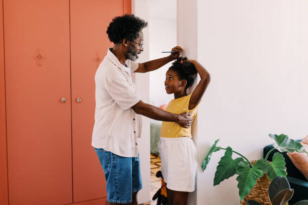 istock Growing up: Father measuring his young daughter's height on a wall 2195270188