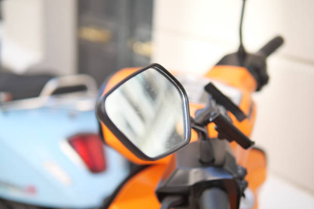 A detailed view of a motorcycle's side mirror showcasing its design and reflection.