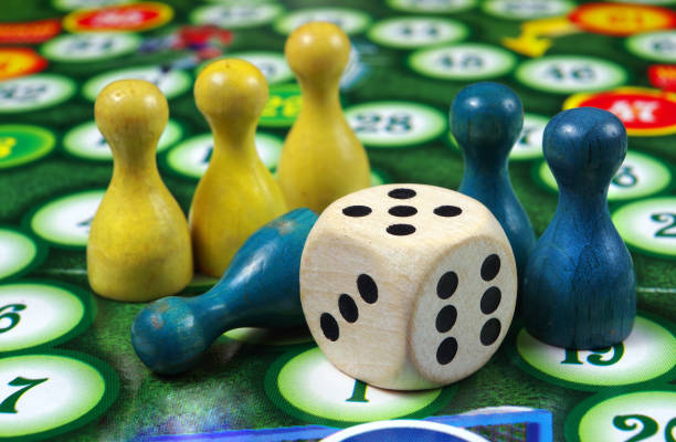 istock colorful play figures with dice on board 2195271210