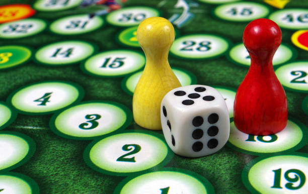 istock colorful play figures with dice on board 2195271958