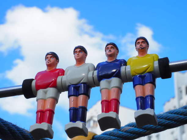 group of colored plastic foosball players on blue sky background
