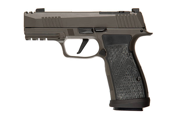 istock Khaki-colored handgun with a textured grip, side view, isolated on a white background, modern firearm design, suitable for self-defense or law enforcement use. 2195273792