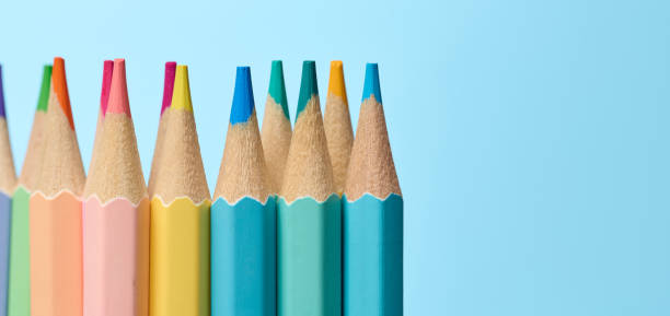 istock Multicolored wooden pencils sharpened on blue background, school supplies 2195279276