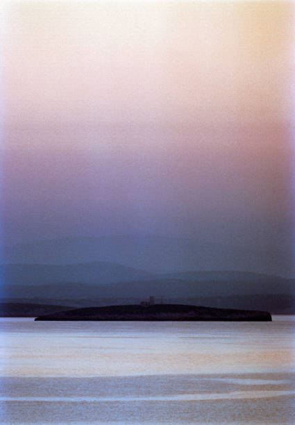 Detail of the coastline at sunrise at a small fishing village at the eastern part of the Greek Island of Chios in the Aegean Sea on a sunny midday in spring (late March). In the background is the Turkish coastline. The image was captured on old-fashioned 35mm daylight ISO 200 film by an analogue (or analog) 35 mm film camera. The granularity in the image is real film grain (due to the presence of small particles of dyed silver halide on the negative). Minimal post processing has been done (only adjustment of histogram). The image is part of a series of the landscape on the Greek Island of Chios.