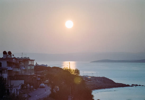 Detail of the coastline at sunrise at a small fishing village at the eastern part of the Greek Island of Chios in the Aegean Sea on a sunny midday in spring (late March). In the background is the Turkish coastline. The image was captured on old-fashioned 35mm daylight ISO 200 film by an analogue (or analog) 35 mm film camera. The granularity in the image is real film grain (due to the presence of small particles of dyed silver halide on the negative). Minimal post processing has been done (only adjustment of histogram). The image is part of a series of the landscape on the Greek Island of Chios.