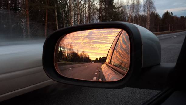 Traveling in the evening summer, reflecting the sky in the car mirror