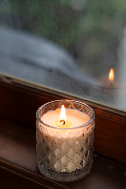 istock Lit Candle on Wooden Windowsill 2195284108