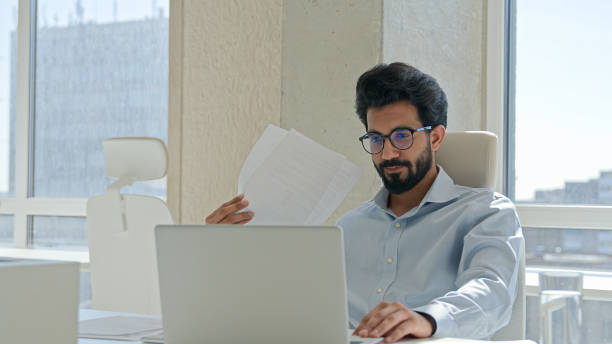 istock Arabian Indian man tired businessman suffer high temperature uncomfortable heat summer blowing waving papers make wind sit in hot office think project on laptop solve problem broken air conditioner 2195284216