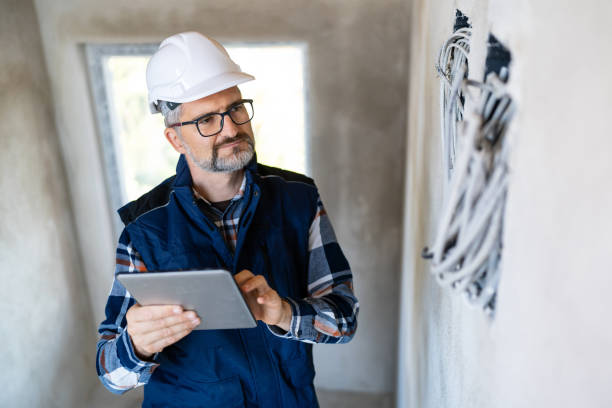 istock Professional Electrician Inspecting Wires on Construction Site Using a Digital Tablet 2195286170
