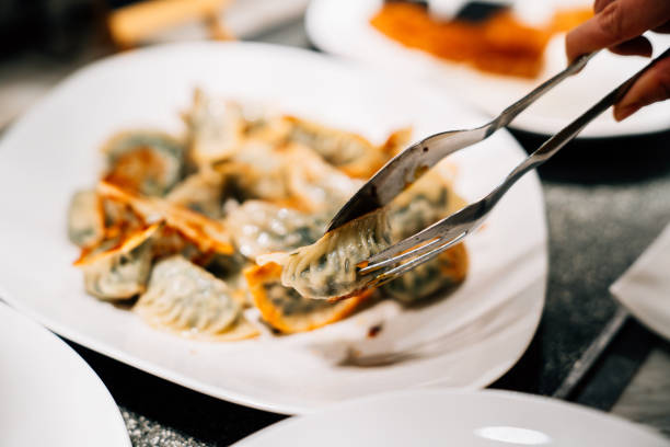 Close up of hand clamping dumplings.