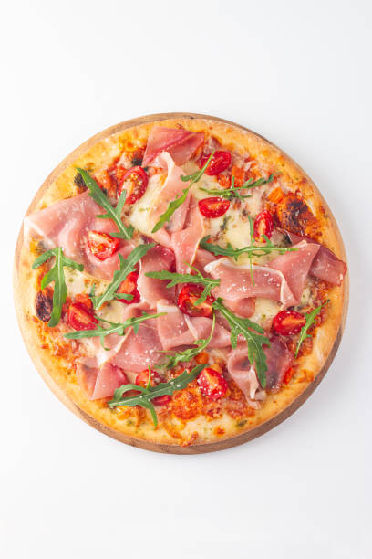 istock Pizza with prosciutto, ham, arugula, spinach, tomatoes, pesto, cheese and parmesan. Italian cuisine 2195286896