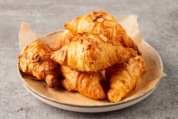 istock Freshly baked croissants with almonds on a plate 2195286972