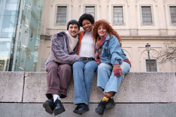 istock Three young friends embracing and smiling at camera 2195291840