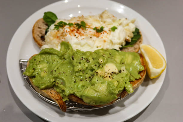 istock sourdough bread toastwith avocado paste with black pepper and egg white crab meat on another slice. Lemon slice on the side 2195293776