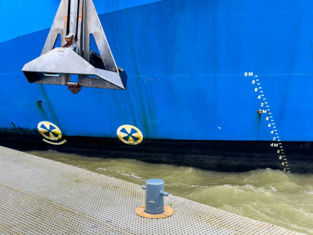 Yellow mooring line or rope on bolder to secure blue  ship at dock