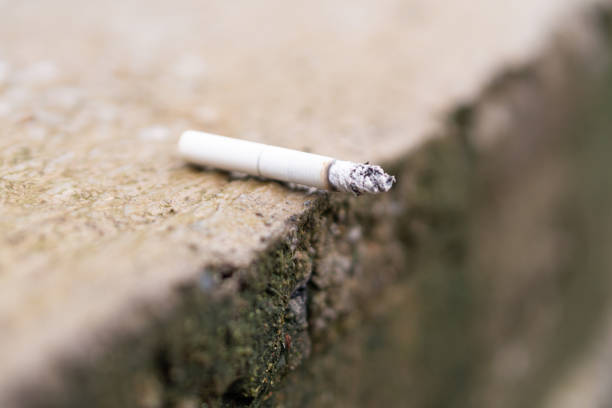 istock Close-Up of a Discarded Cigarette on Rough Surface 2195299225