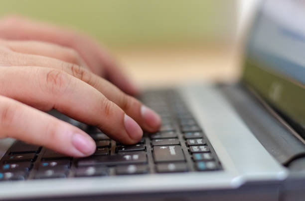Close up image of a man hands writing on a laptop