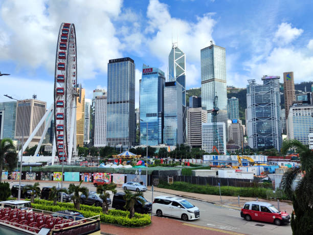 Ferris wheel and Hong Kong modern skyline in Central district.